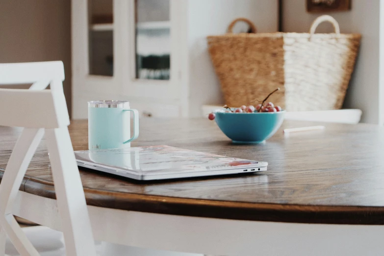 a bowl of fruit sitting on top of a wooden table, pexels contest winner, home office interior, table in front with a cup, teal aesthetic, family friendly