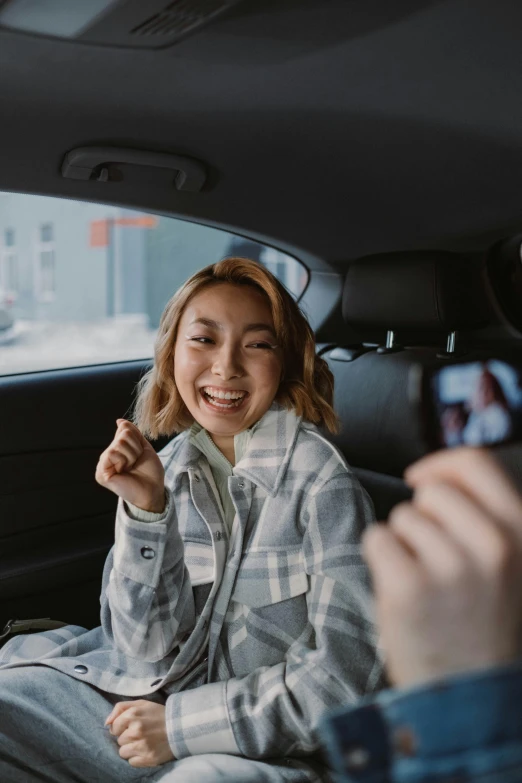 a woman taking a picture of herself in the back seat of a car, pexels contest winner, happening, pokimane, smiling laughing, japanese model, medium shot of two characters