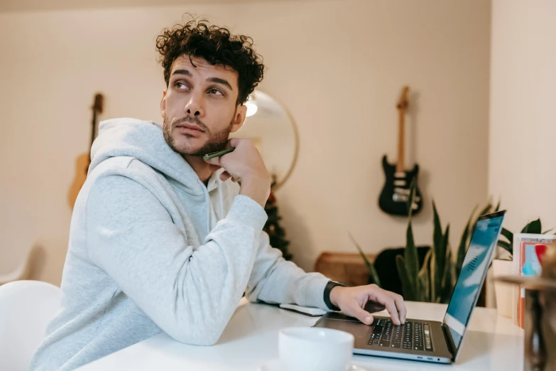 a man sitting in front of a laptop computer, trending on pexels, looking off to the side, dylan kowalsk, thumbnail, high quality image