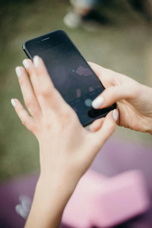 a close up of a person holding a cell phone, a picture, digital image, afternoon, square, recreation