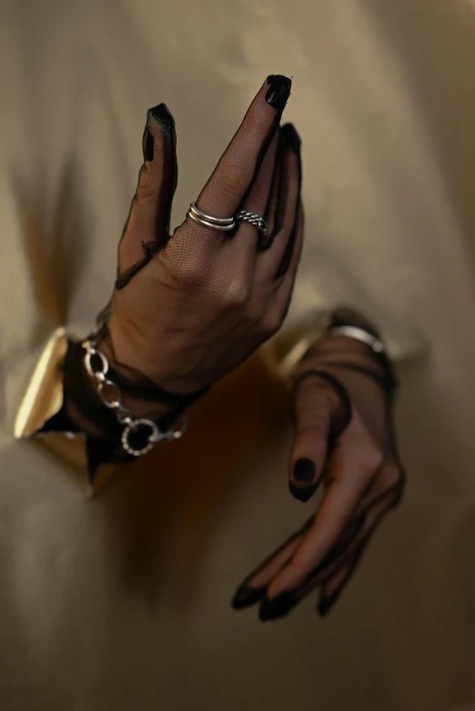 a close up of a person's hands with rings on them, an album cover, inspired by Elsa Bleda, renaissance, woman in black robes, middle eastern skin, silver and gold, leather jewelry
