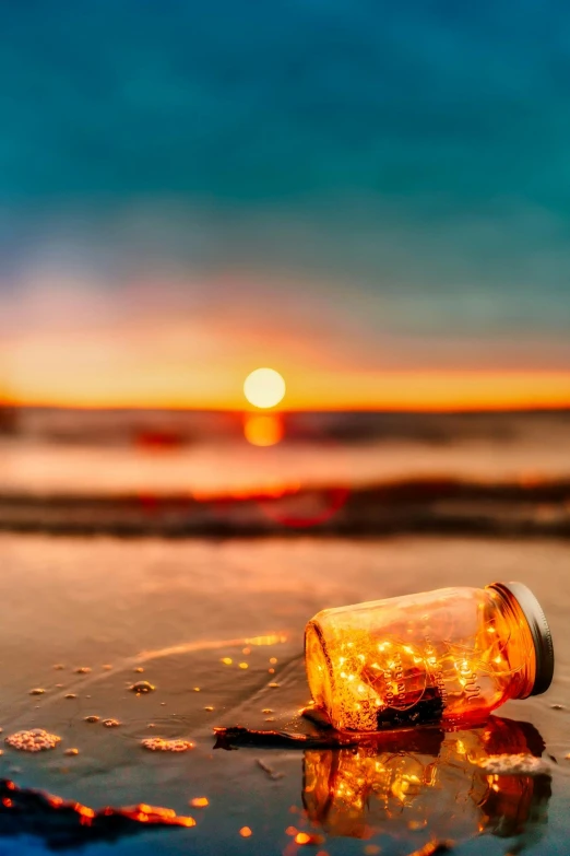 a bottle sitting on top of a beach next to the ocean, at the sunset, inside a glass jar, golden sun, golden hour firefly wisps