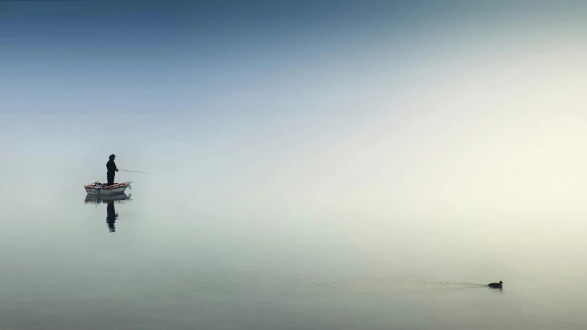 a man standing on top of a boat in the middle of a lake, inspired by Michal Karcz, unsplash, minimalism, pale blue fog, very long shot of a windmill, panoramic photography, the dead sea