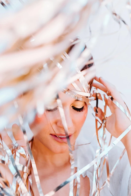a woman standing in front of a bunch of tinsel, aestheticism, white lashes, foil, post graduate, contemplating