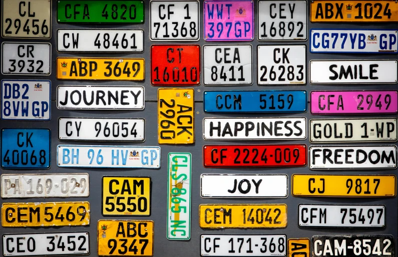a bunch of license plates on a wall, by Joe Bowler, pexels, square, highly detailed photo of happy, on black background, colorful scene