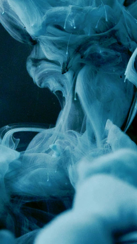 a close up of a person holding a cell phone, inspired by Alberto Seveso, pexels, process art, whirling blue smoke, film still from horror movie, translucent sss xray, curls