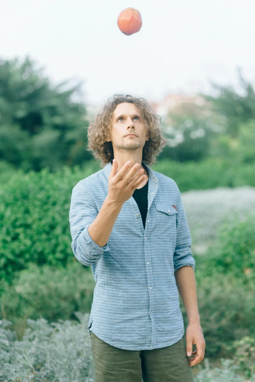 a man tossing an apple in the air, an album cover, unsplash, curly haired, pondering, with index finger, ryan dening