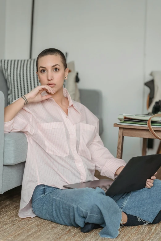 a woman sitting on the floor with a laptop, a portrait, by Carey Morris, trending on pexels, renaissance, pink shirt, shaved hair, wearing a linen shirt, portrait sophie mudd