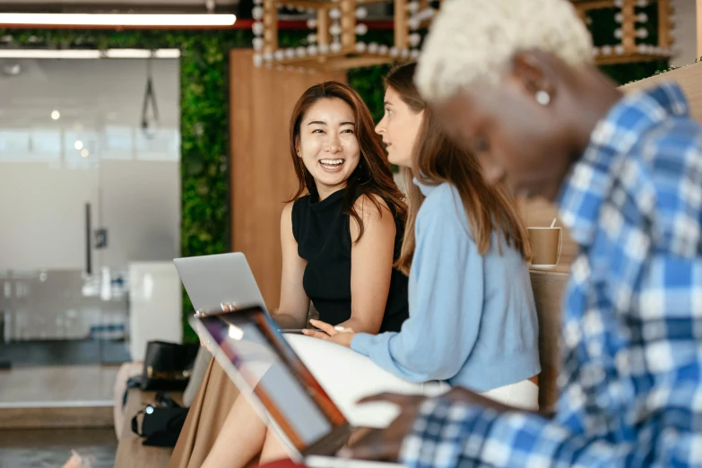 a group of people sitting around a table with a laptop