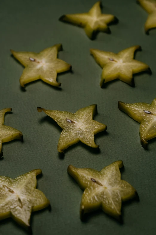 a bunch of star shaped cookies on a table, a macro photograph, by Julia Pishtar, selena gomez made out of celery, mezzotint, pods, cut out