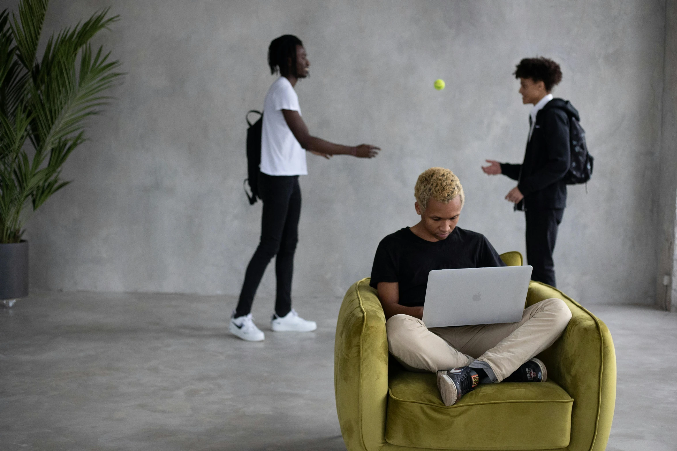 a man sitting in a chair with a laptop on his lap, trending on pexels, happening, group of people, black teenage boy, decoration, working out