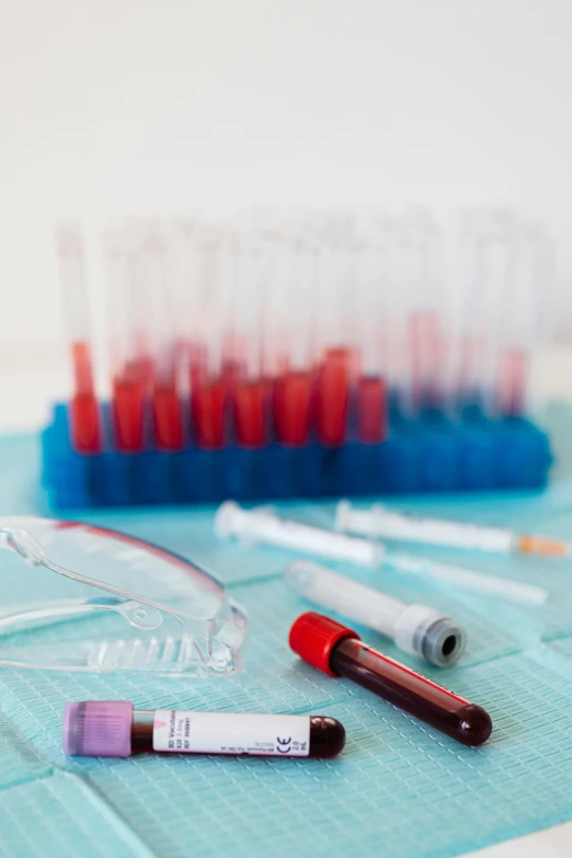 a bunch of test tubes sitting on top of a table, blue and red color palette, surgical supplies, amanda lilleston, medical research facility