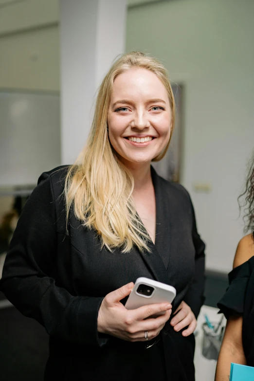 a couple of women standing next to each other, holds a smart phone in one hand, close up of a blonde woman, samma van klaarbergen, smiling for the camera