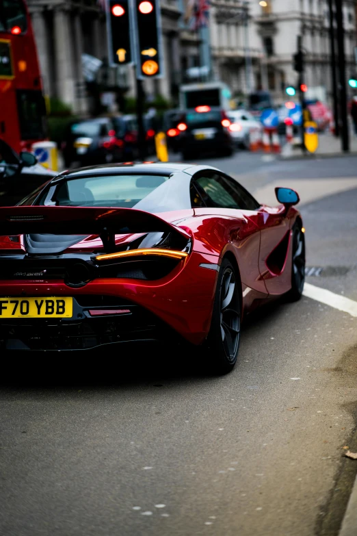 a red sports car driving down a city street, by Tom Bonson, pexels contest winner, mclaren, square, back, london