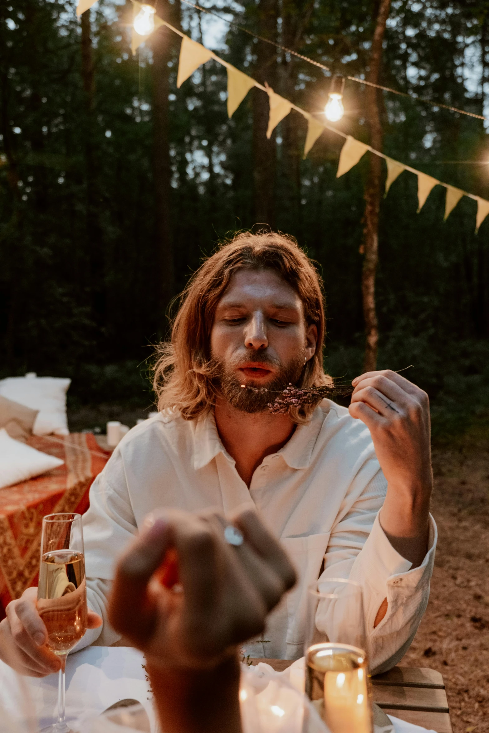 a group of people sitting around a table eating food, an album cover, by Jan Tengnagel, pexels contest winner, evening!! in the forest, bearded beautiful man, cottagecore hippie, close up portrait shot