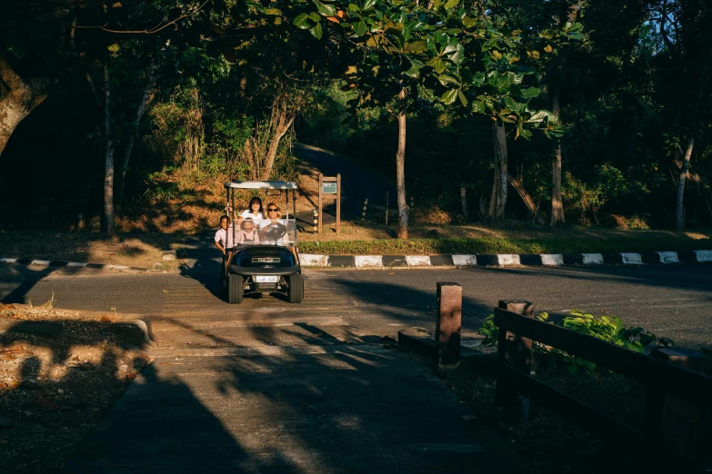 a group of people riding on the back of a golf cart, by Tobias Stimmer, pexels contest winner, bali, well shaded, paved roads, thumbnail