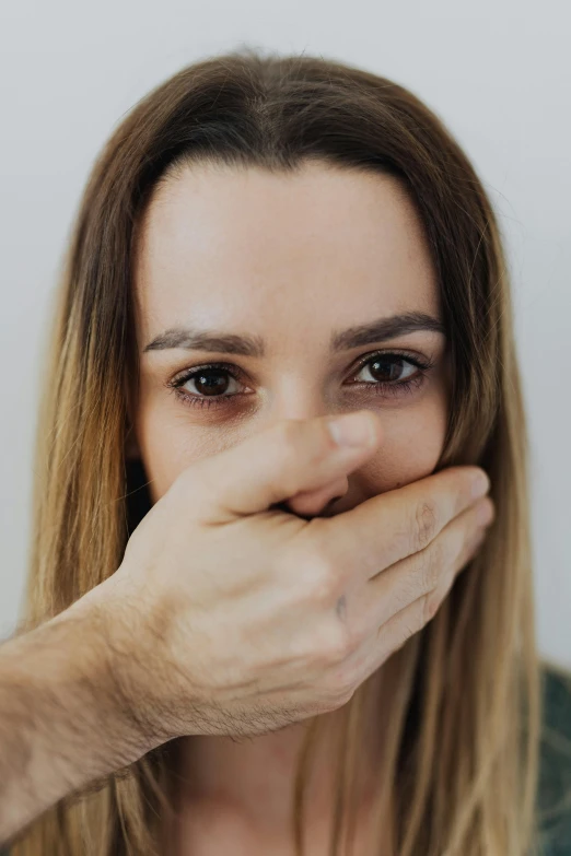 a woman covering her mouth with her hands, a picture, shutterstock, antipodeans, large nose, punching, close-up shoot, multiple stories