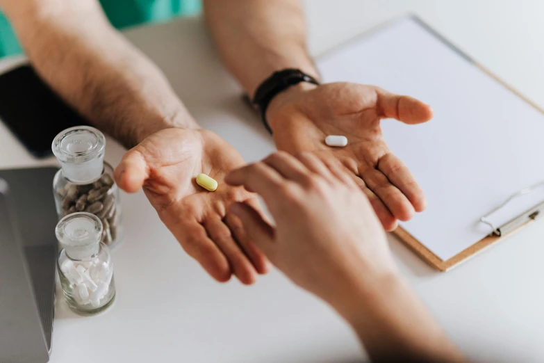 a man taking a pill from a woman's hand, a photo, by Emma Andijewska, trending on pexels, renaissance, candy treatments, back of hand on the table, medical labels, thumbnail