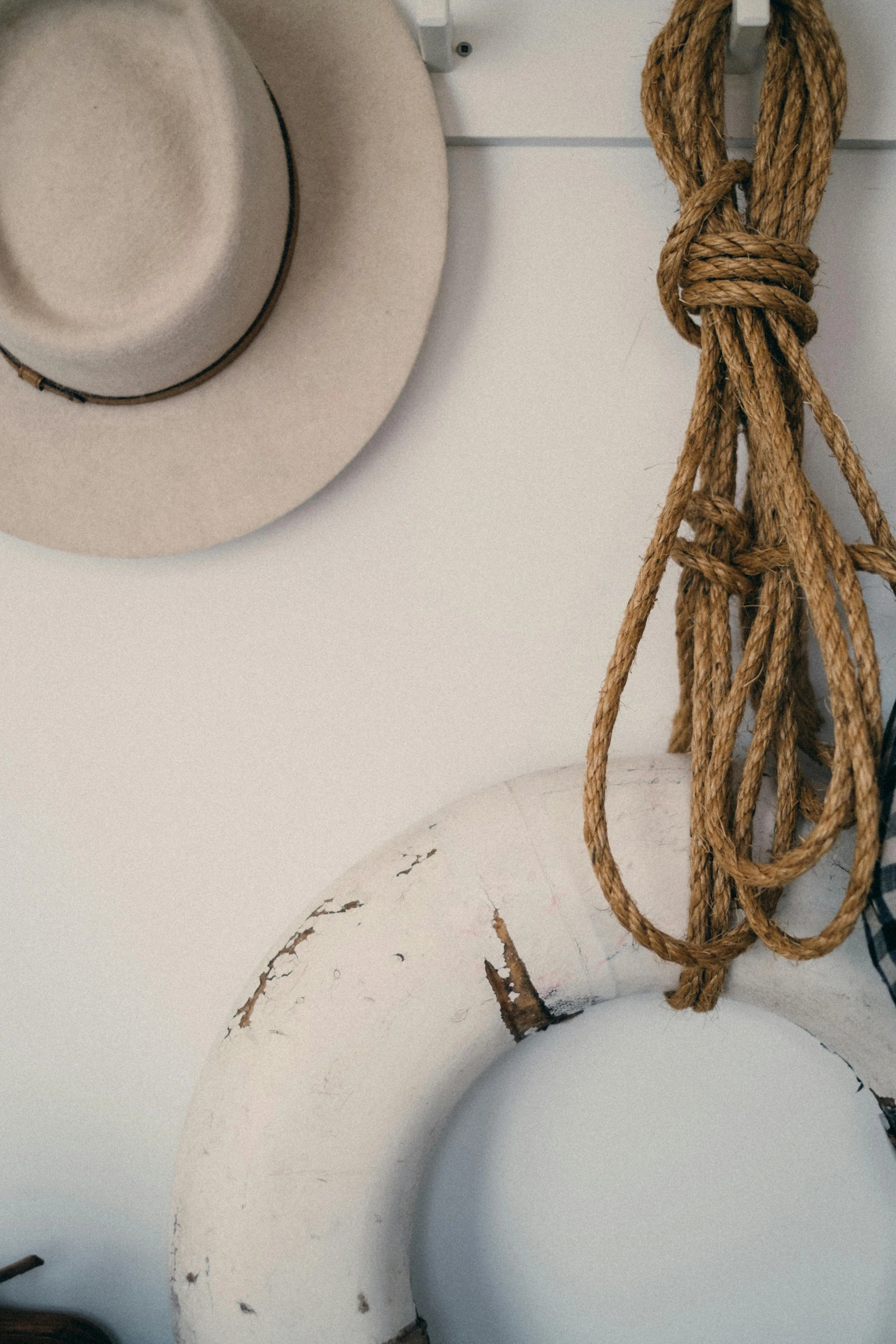 a bunch of hats and a life preserver hanging on a wall, inspired by Joseph Beuys, pexels contest winner, detail shot, rope, silver，ivory, lachlan bailey