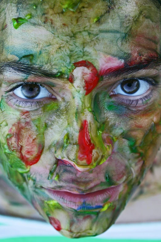 a close up of a person with paint on their face, process art, slimey, green and red tones, multicolored faces, mess