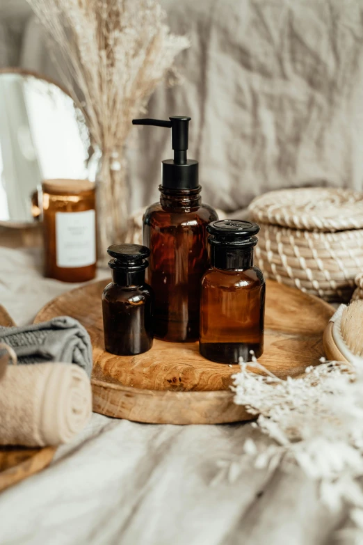 a bunch of bottles sitting on top of a wooden tray, a still life, by Julia Pishtar, unsplash, soap, amber, full face, boho chic