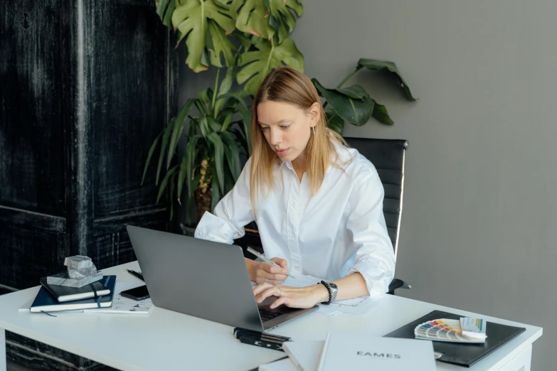 a woman sitting at a desk using a laptop computer, pexels contest winner, wearing a white button up shirt, avatar image, dasha taran, stacked image