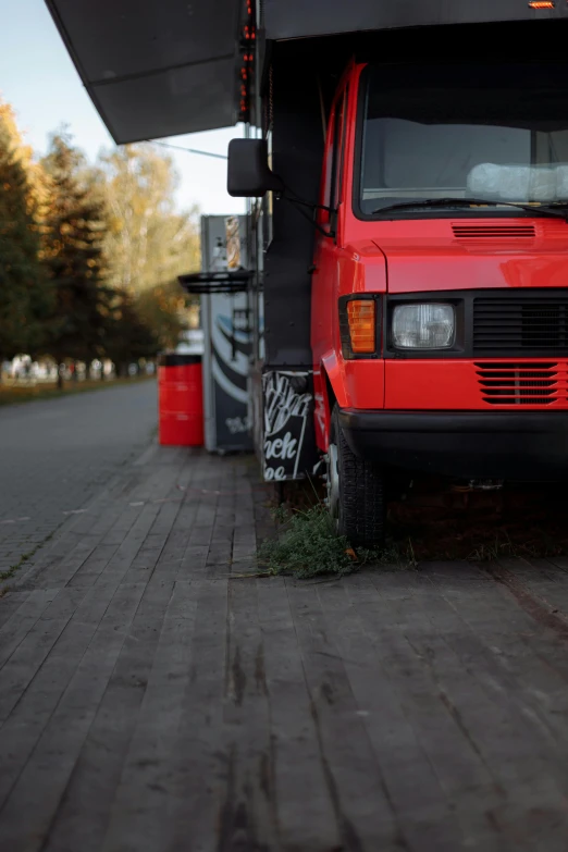 a red truck parked on the side of a road, by Attila Meszlenyi, street of moscow, low quality photo, small details, van