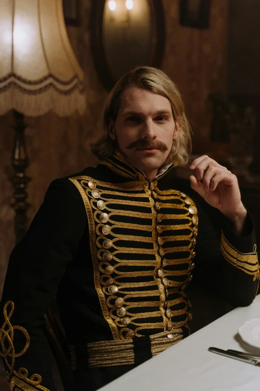 a man in a military uniform sitting at a table, an album cover, inspired by Louis Buvelot, trending on pexels, renaissance, huge blond moustache, movie still frame, royal robe, both wearing victorian clothes