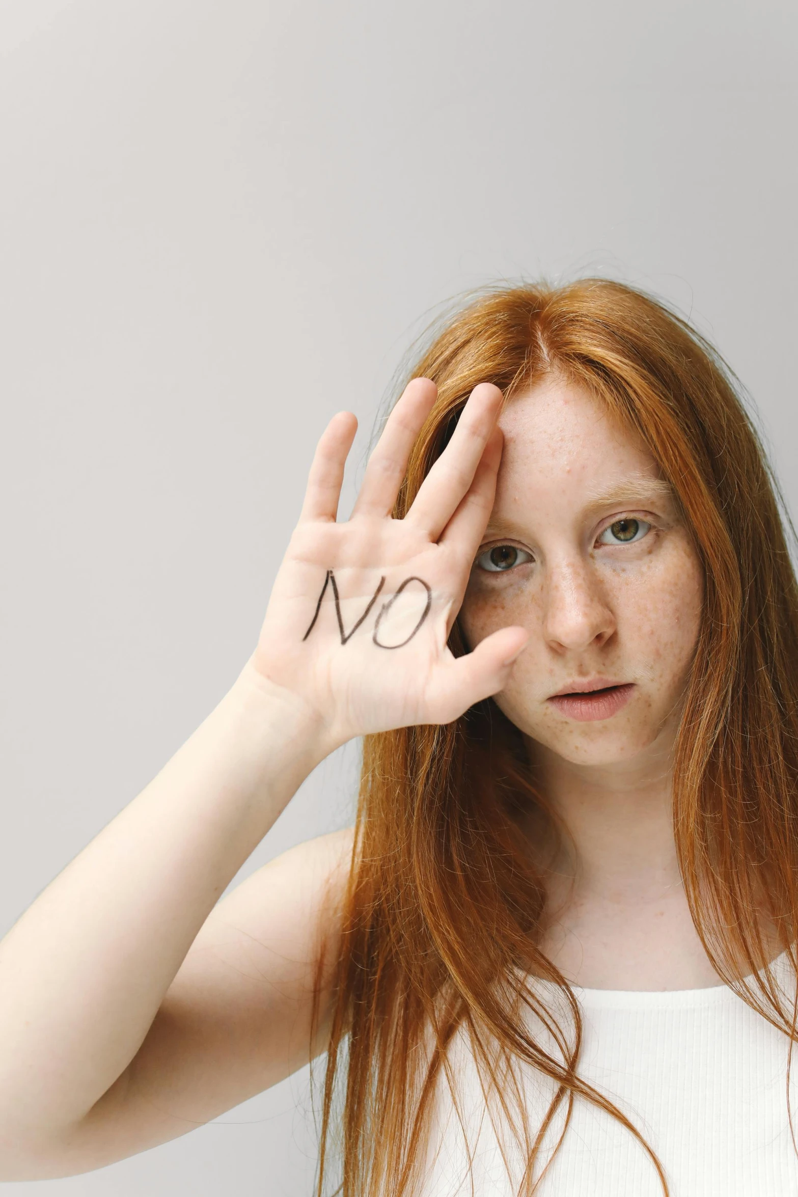 a woman holding up her hand with the word love written on it, an album cover, by Arabella Rankin, shutterstock, renaissance, ginger hair with freckles, young angry woman, studio shoot, no - text no - logo