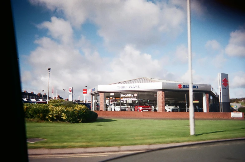 a car dealership sitting on the side of a road, unsplash, photorealism, maryport, three head one body, square, thomas eakes