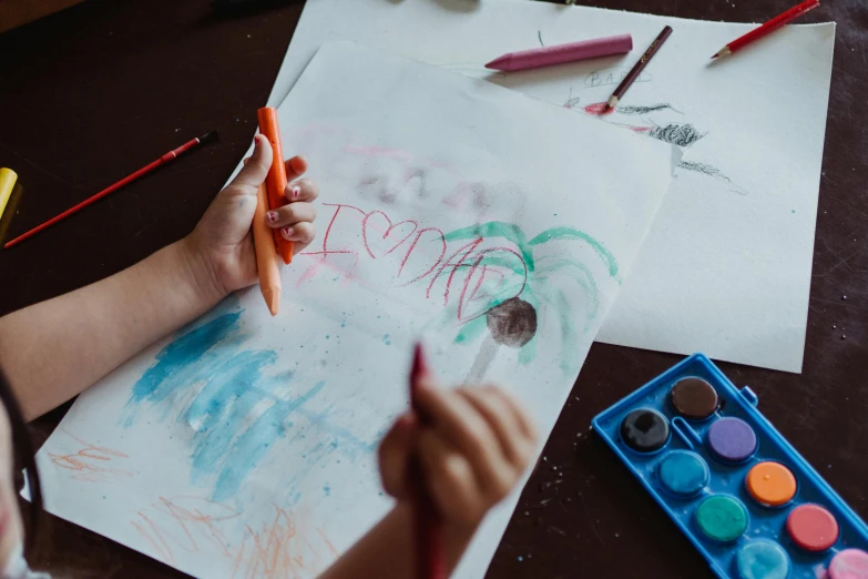 a child is drawing on a piece of paper, a child's drawing, by Emma Andijewska, pexels contest winner, love art, thumbnail, high quality photo, artststion