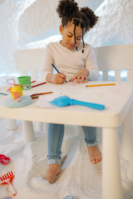 a little girl that is sitting at a table, inspired by Rachel Whiteread, pexels contest winner, winter snow, innovative product concepts, ameera al-taweel, detail shot