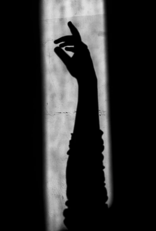 a black and white photo of a hand reaching out of a window, a black and white photo, by Alexis Grimou, conceptual art, silhouette :7, dayanita singh, promo image, female image in shadow
