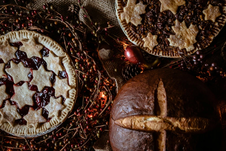a couple of pies sitting on top of a table, a still life, by Julia Pishtar, pexels contest winner, folk art, holiday season, background image, high angle close up shot, cakes