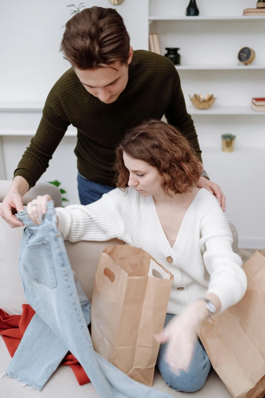 a couple of people that are sitting on a couch, getting groceries, touching her clothes, supportive, slightly minimal