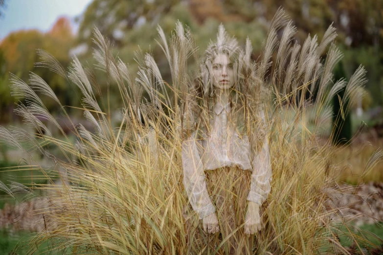 a woman standing in a field of tall grass, inspired by Elsa Bleda, magic realism, portrait image, ignant, hair made of shimmering ghosts, 2022 photograph