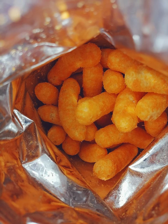 a bag of cheetoes sitting on top of a table, inspired by Pia Fries, unsplash, rockets, square, shrimp, shiny silver