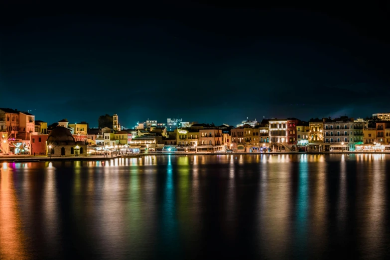 a large body of water next to a city at night, by Michalis Oikonomou, pexels contest winner, waterfront houses, high resolution print :1 cmyk :1, greek fantasy panorama, aruba