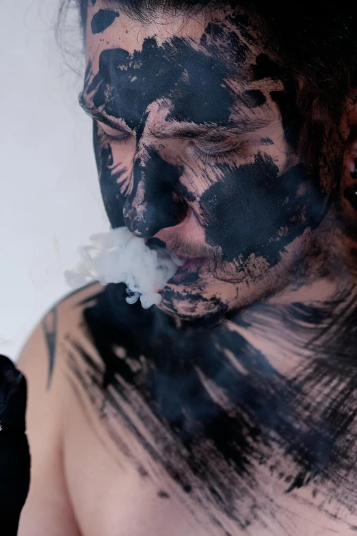 a man with black paint on his face smoking a cigarette, reddit, transgressive art, thick swirling smoke, nsfw, ink blot, photograph taken in 2 0 2 0