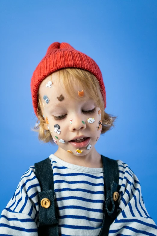 a little boy with face paint on his face, a child's drawing, inspired by Hikari Shimoda, trending on pexels, wearing a french beret, sprinkles, sleepy expression, mini model