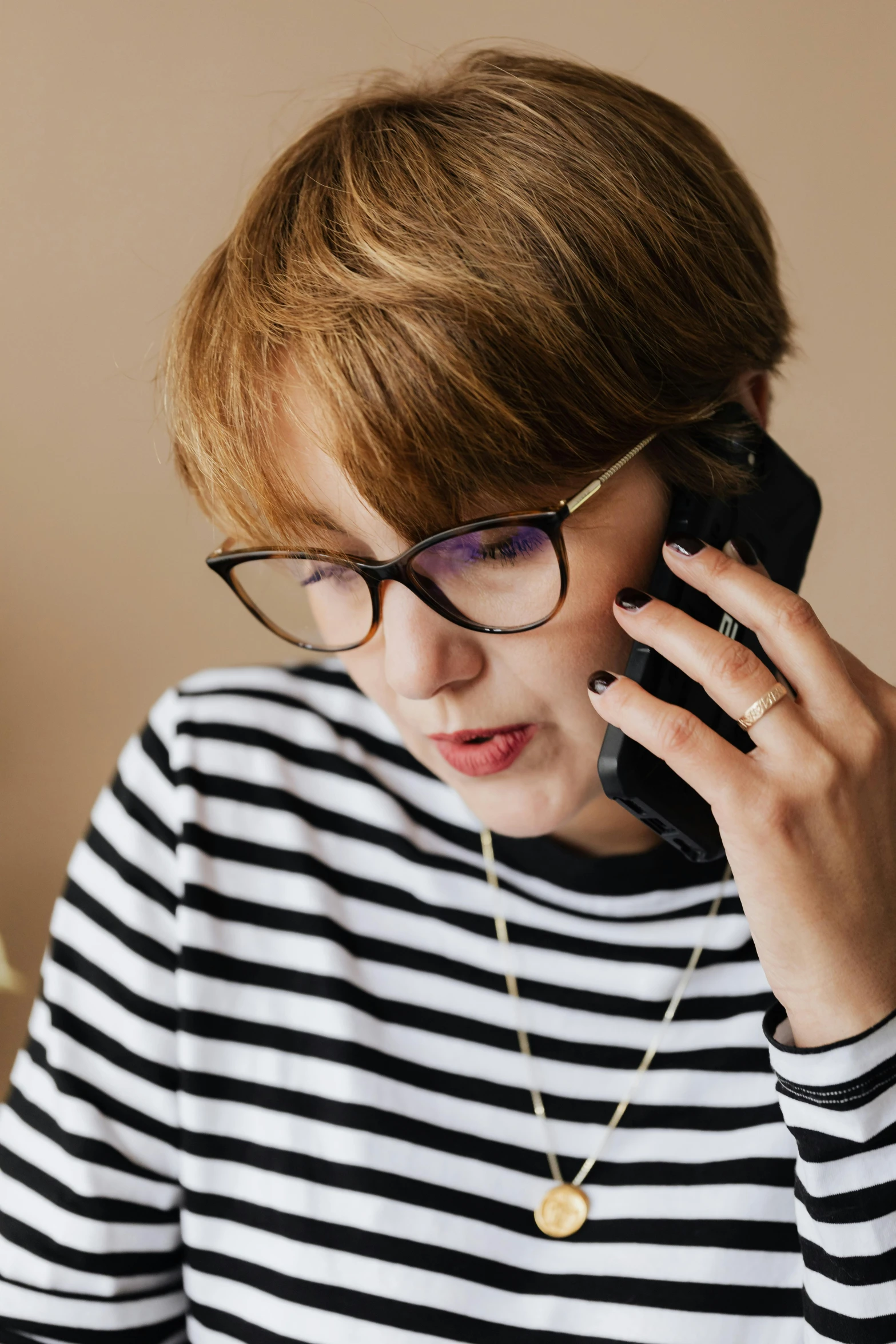 a woman wearing glasses talking on a cell phone, curated collections, lgbtq, realistic »