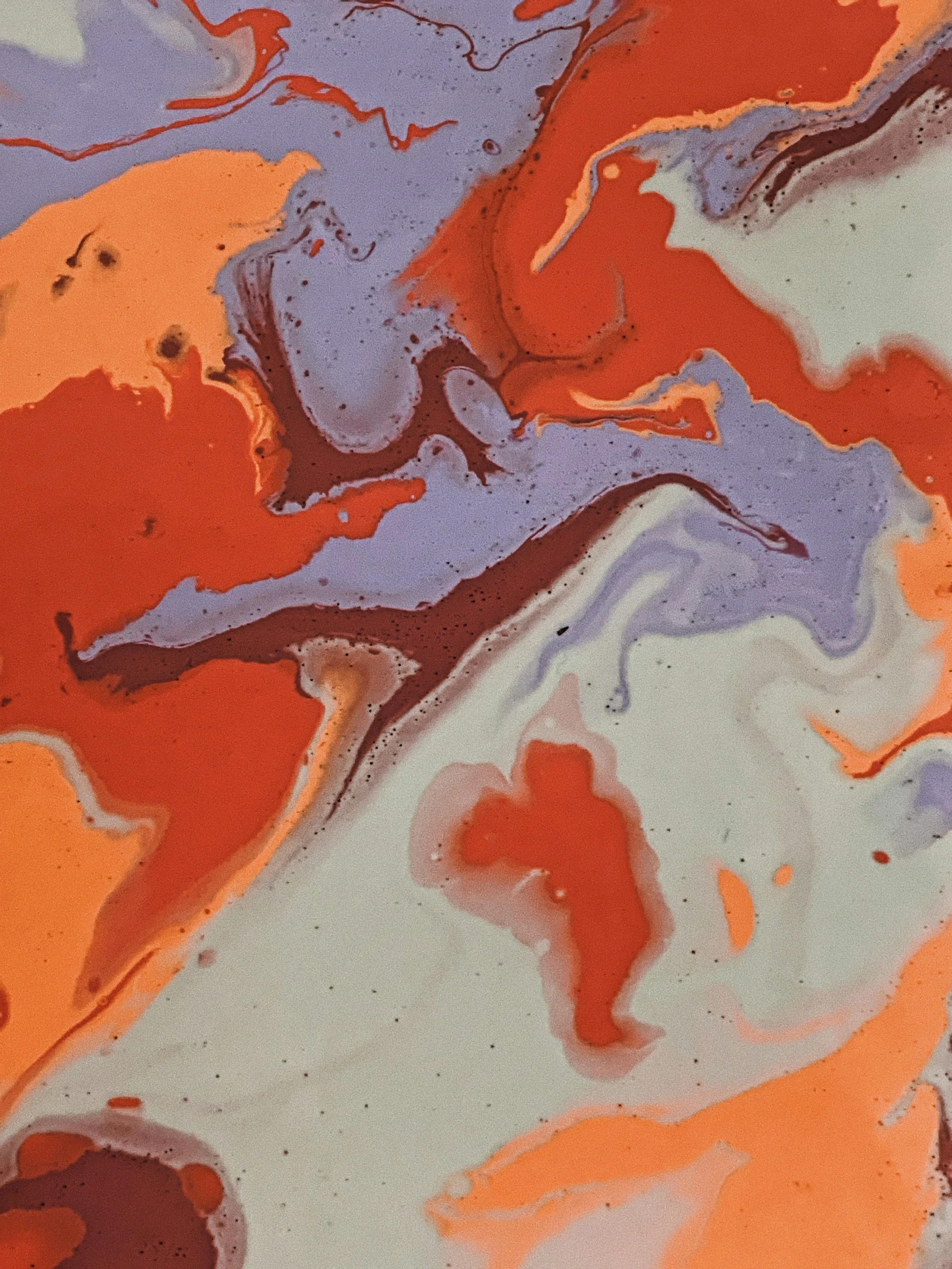 a close up of a piece of art on a table, by Mandy Jurgens, reddit, lyrical abstraction, orange and purple color scheme, marbled, gray and orange colours, desert colors