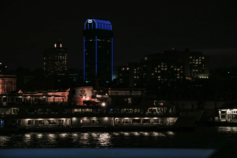 a boat that is sitting in the water, by Carey Morris, pexels contest winner, renaissance, neon tokyo, blue and orange rim lights, viewed from the harbor, on black background