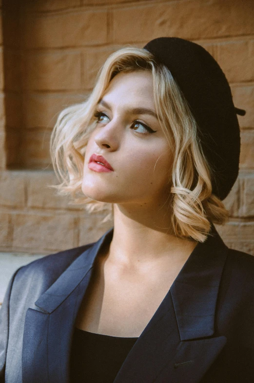 a woman standing in front of a brick wall, inspired by Elsa Bleda, trending on pexels, renaissance, black beret, portrait of annasophia robb, short wavy hair, girl in suit