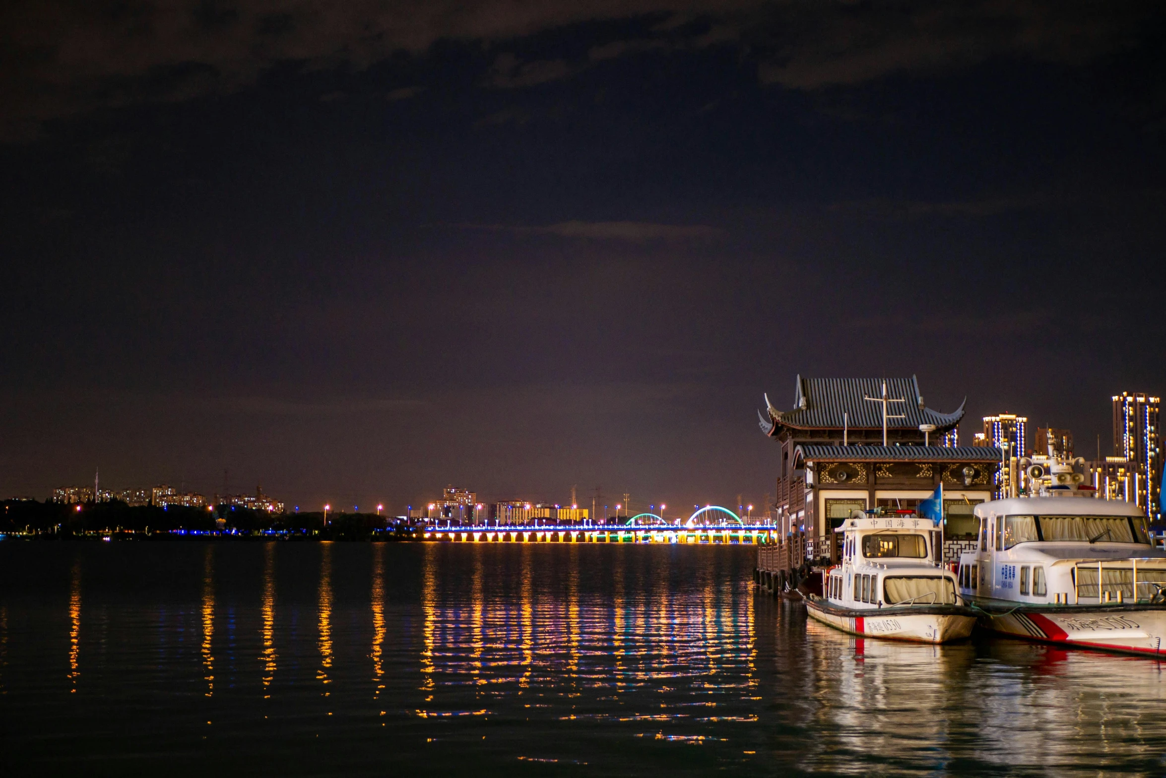 a couple of boats that are sitting in the water, by Jang Seung-eop, pexels contest winner, nightlife, trampling over pyongyang, steamboat willy, cover photo portrait of du juan