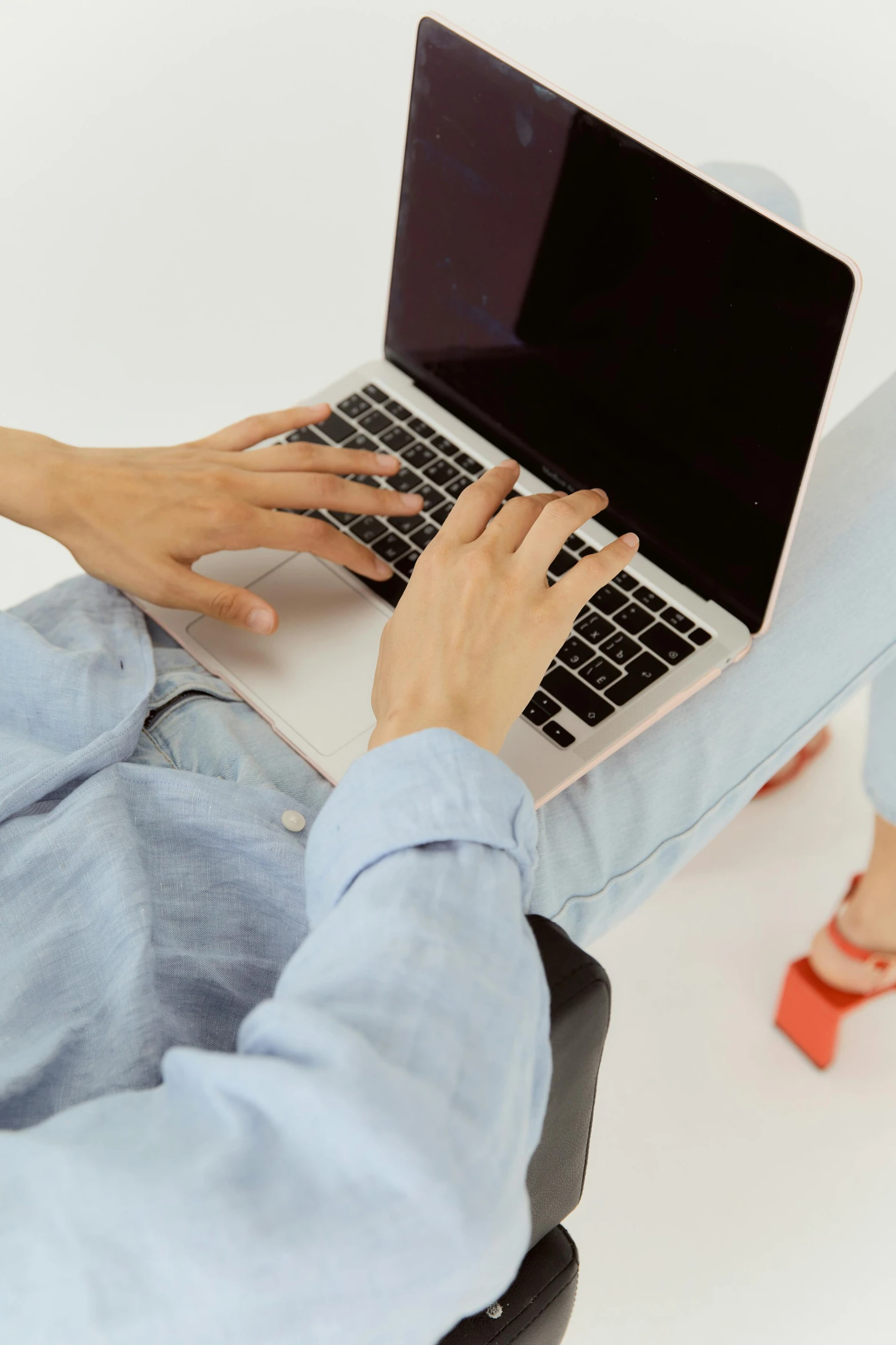 a man sitting in a chair using a laptop computer, trending on pexels, wearing a cropped top, double layer fold over hem, text and a pale young woman, high angle