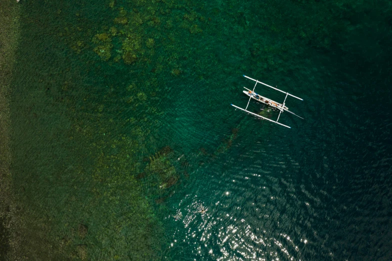 a small boat floating on top of a body of water, by Jessie Algie, pexels contest winner, philippines, airborne view, an ancient greek trireme, full frame image
