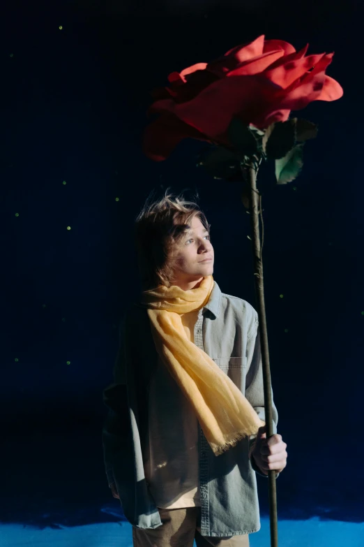 a man standing in the snow holding a rose, an album cover, by Billie Waters, magical realism, flume, ( ( theatrical ) ), show, press photos