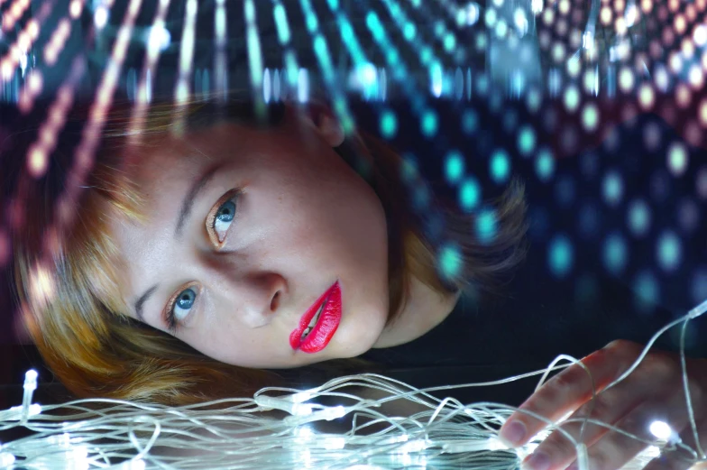 a close up of a person holding a string of lights, a hologram, holography, imogen poots, lying on an abstract, wires cybernetic implants, portrait photo