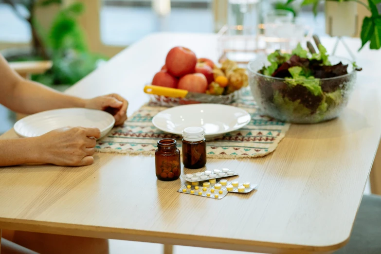 a woman sitting at a table with a plate of food, pills and medicine, on a wooden desk, profile image, high quality product image”